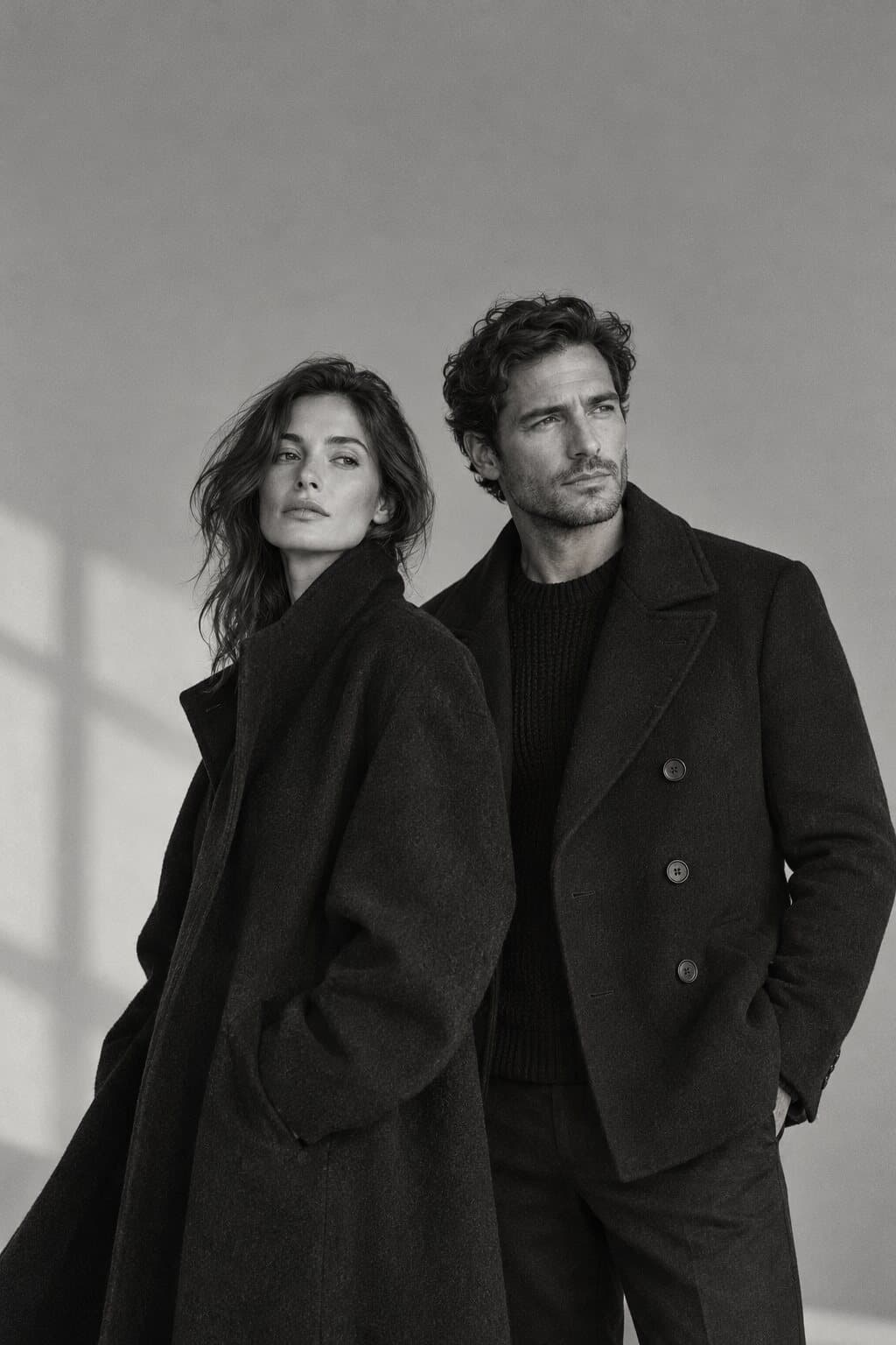 A woman and a man in dark wool coats, black and white